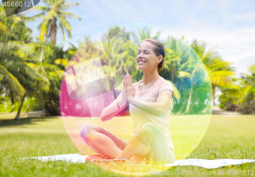 Image of happy woman meditating in summer park over aura