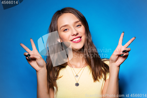 Image of young woman or teenage girl showing peace sign