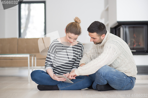 Image of Young Couple using digital tablet on cold winter day