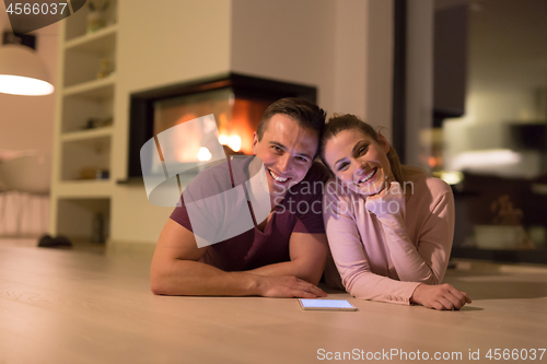 Image of Young Couple using digital tablet on cold winter night