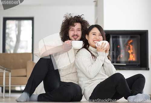 Image of happy multiethnic couple  in front of fireplace