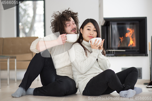 Image of happy multiethnic couple  in front of fireplace