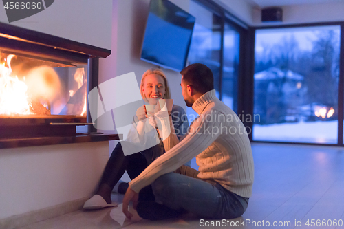 Image of happy couple in front of fireplace