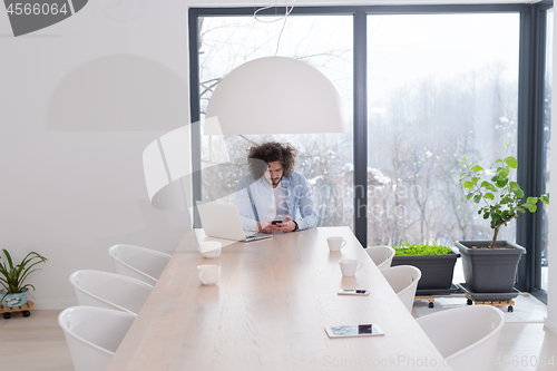 Image of Young casual businessman using smartphone