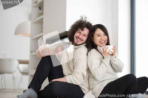 Image of happy multiethnic couple  in front of fireplace