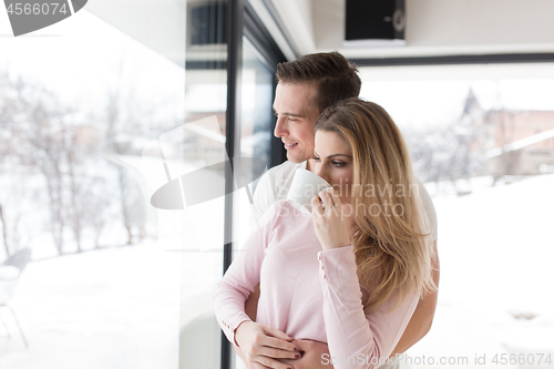 Image of young couple enjoying morning coffee by the window