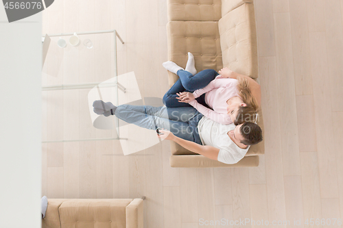 Image of Young couple on the sofa watching television top view