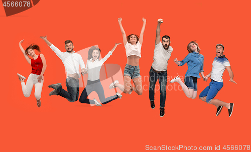 Image of Freedom in moving. young man and women jumping against red background