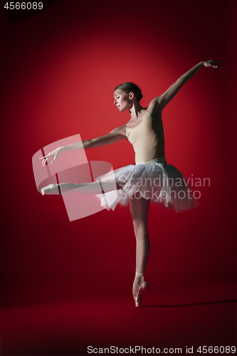 Image of Ballerina. Young graceful female ballet dancer dancing at red studioskill. Beauty of classic ballet.