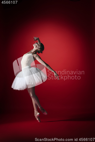 Image of Ballerina. Young graceful female ballet dancer dancing at red studioskill. Beauty of classic ballet.