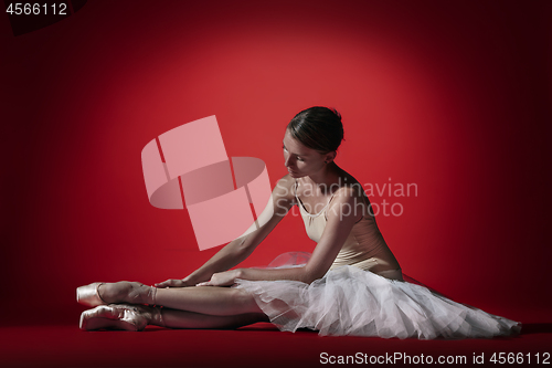 Image of Ballerina. Young graceful female ballet dancer dancing at red studioskill. Beauty of classic ballet.