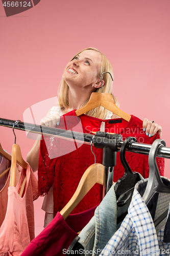 Image of The young pretty girl looking at dresses and try on it while choosing at shop