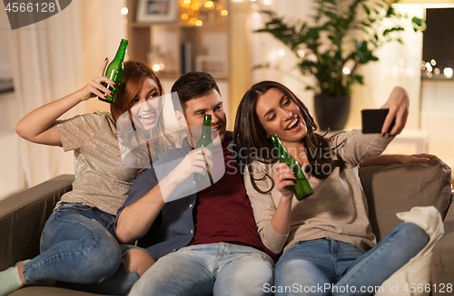 Image of happy friends taking selfie by smartphone at home