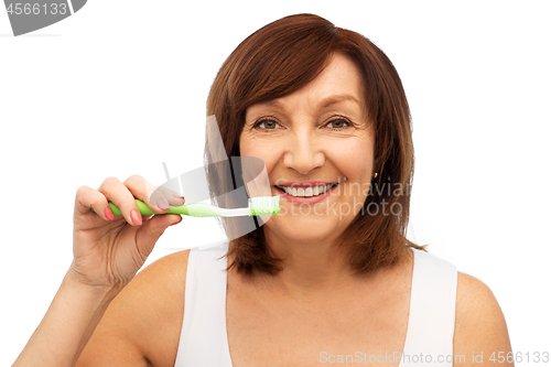 Image of senior woman with toothbrush brushing her teeth