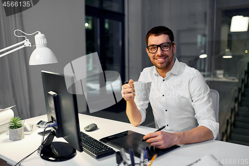 Image of designer with pen tablet drinking coffee at office