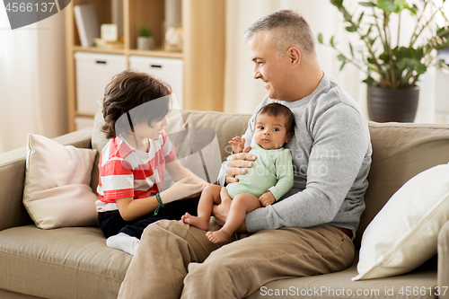 Image of happy father with preteen and baby son at home