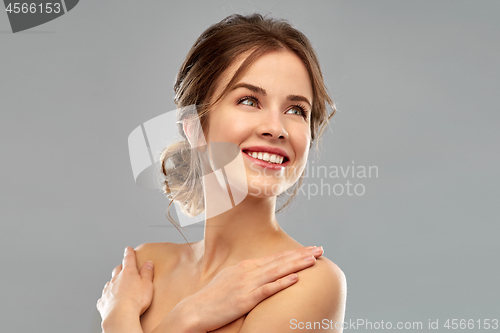 Image of smiling young woman over grey background