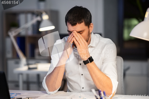 Image of tired businessman working at night office