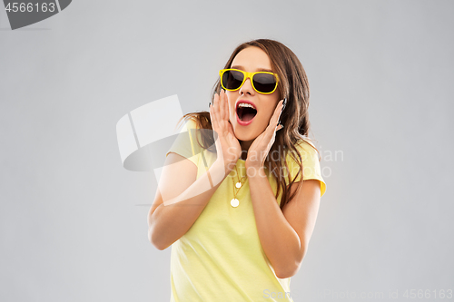 Image of amazed teenage girl in yellow sunglasses