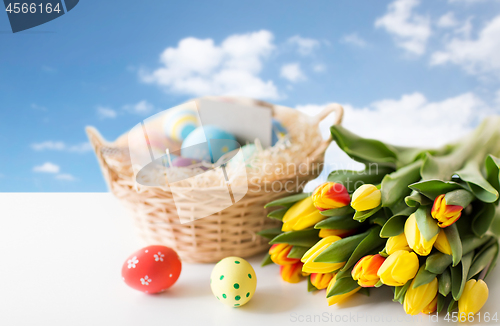 Image of close up of colored easter eggs and tulip flowers