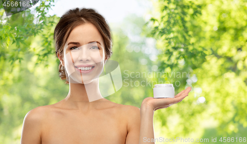 Image of happy young woman holding jar of cream