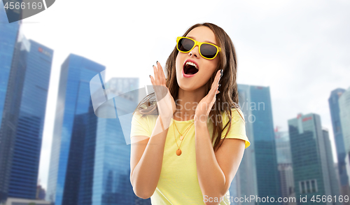 Image of amazed teenage girl in sunglasses at singapore