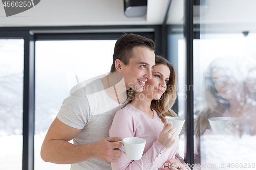 Image of young couple enjoying morning coffee by the window