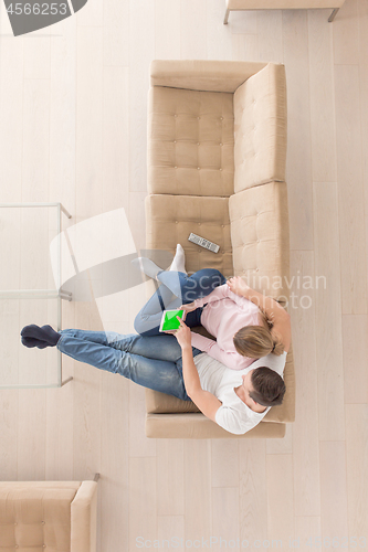 Image of young couple in living room using tablet top view