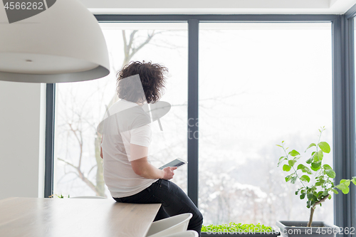 Image of young man using a tablet at home