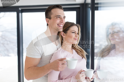 Image of young couple enjoying morning coffee by the window