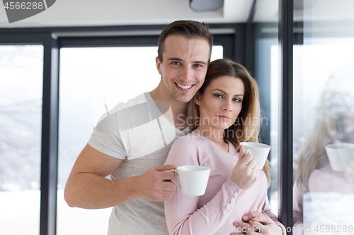 Image of young couple enjoying morning coffee by the window