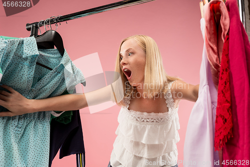 Image of The young pretty girl looking at dresses and try on it while choosing at shop