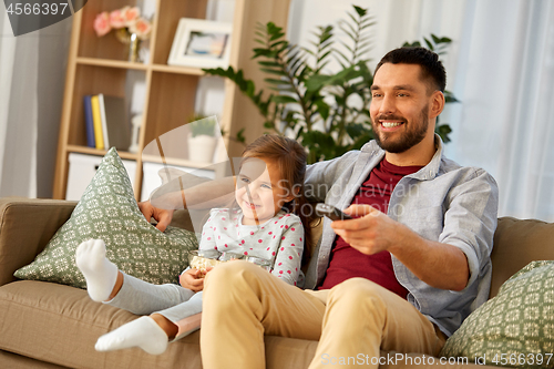 Image of happy father and daughter watching tv at home