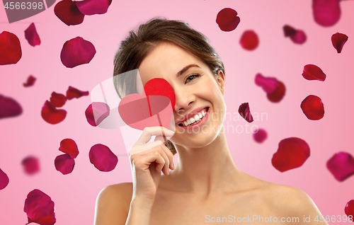 Image of beautiful smiling woman holding red heart