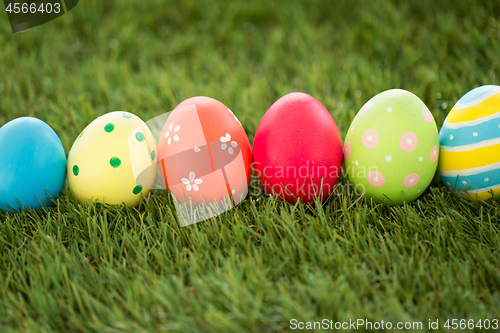 Image of row of colored easter eggs on artificial grass