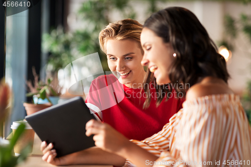 Image of female friends with tablet pc and coffee at cafe