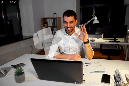 Image of businessman having video chat at night office