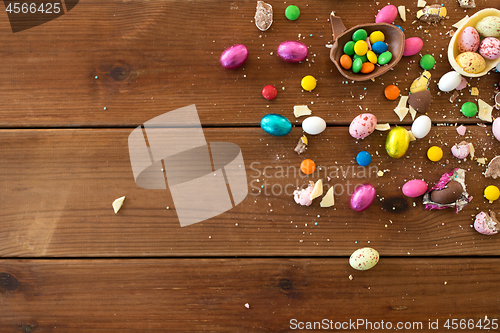 Image of chocolate eggs and candy drops on wooden table