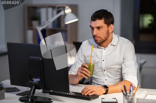 Image of businessman with computer working at night office