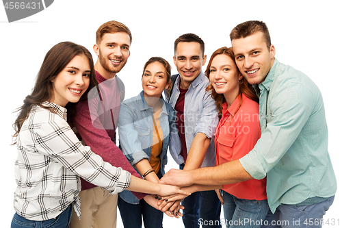 Image of group of smiling friends stacking hands
