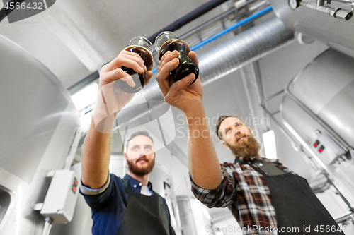 Image of brewers clinking glasses of craft beer at brewery