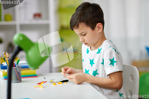 Image of little boy playing with building kit at home