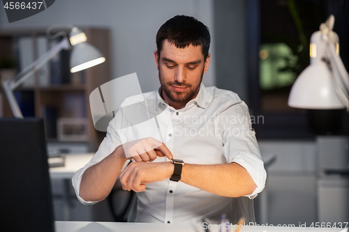 Image of happy businessman with smart watch at nigh office