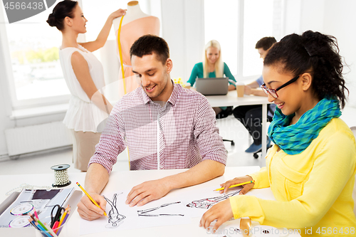 Image of fashion designers drawing sketches at studio
