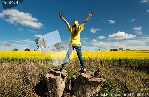 Image of Woman enjoys the countryside views fields of golden canola