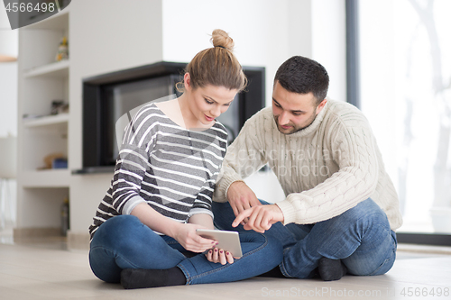 Image of Young Couple using digital tablet on cold winter day