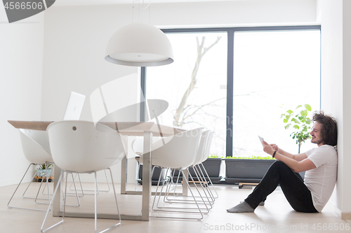 Image of young man using a tablet at home