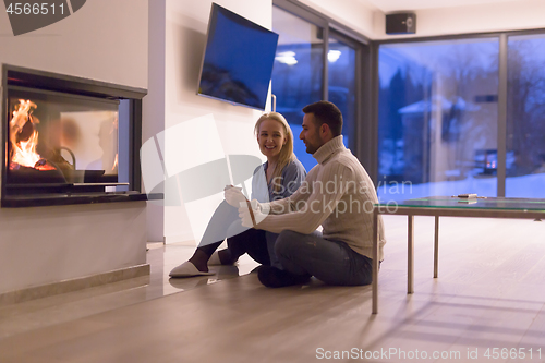 Image of happy couple in front of fireplace