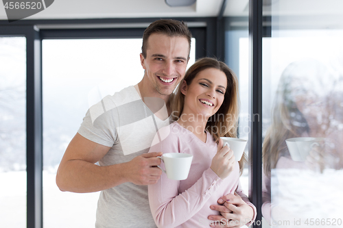 Image of young couple enjoying morning coffee by the window