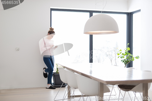 Image of young woman using tablet computer on the floor